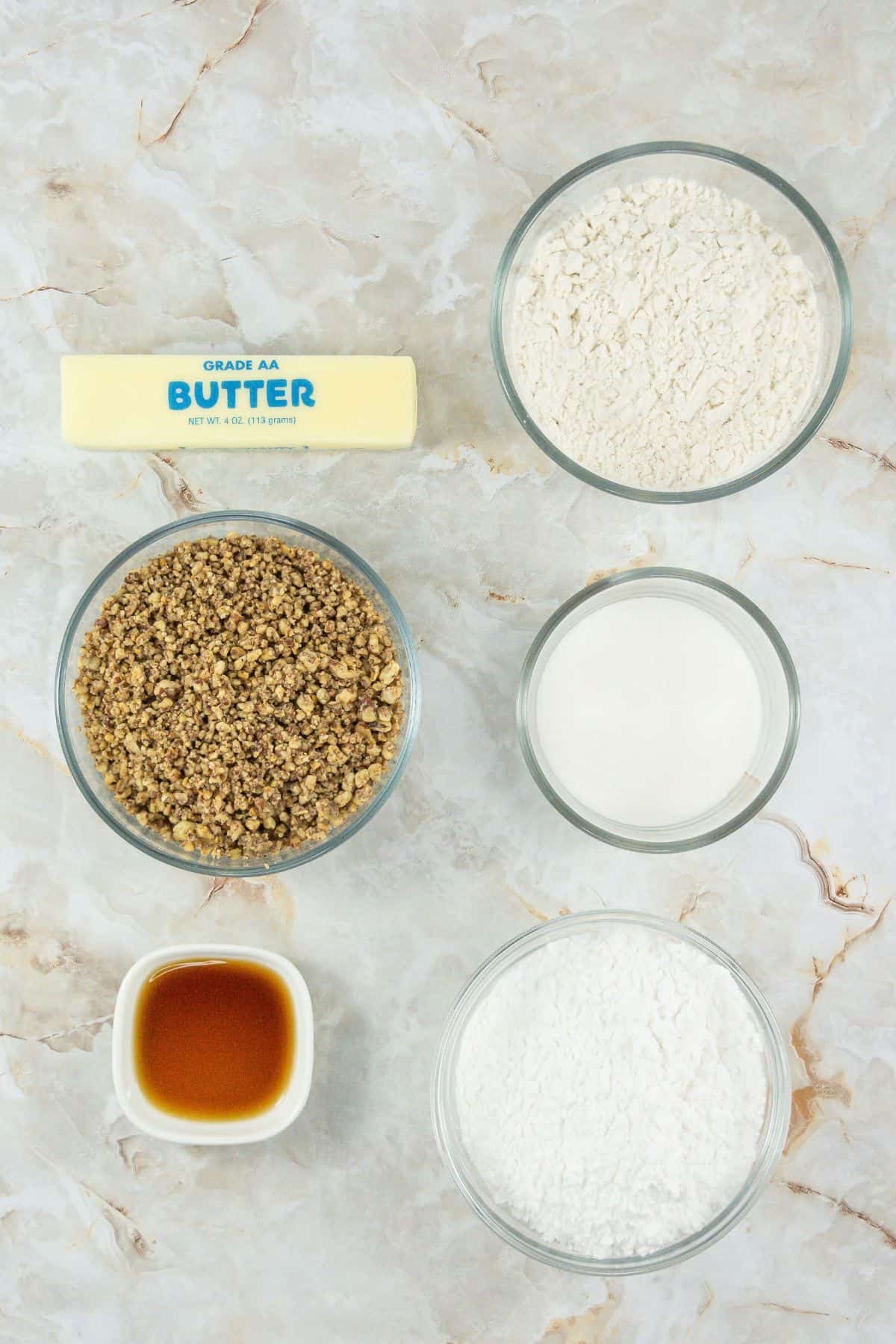 All key ingredients for Butter Pecan Meltaways are displayed on a marble surface