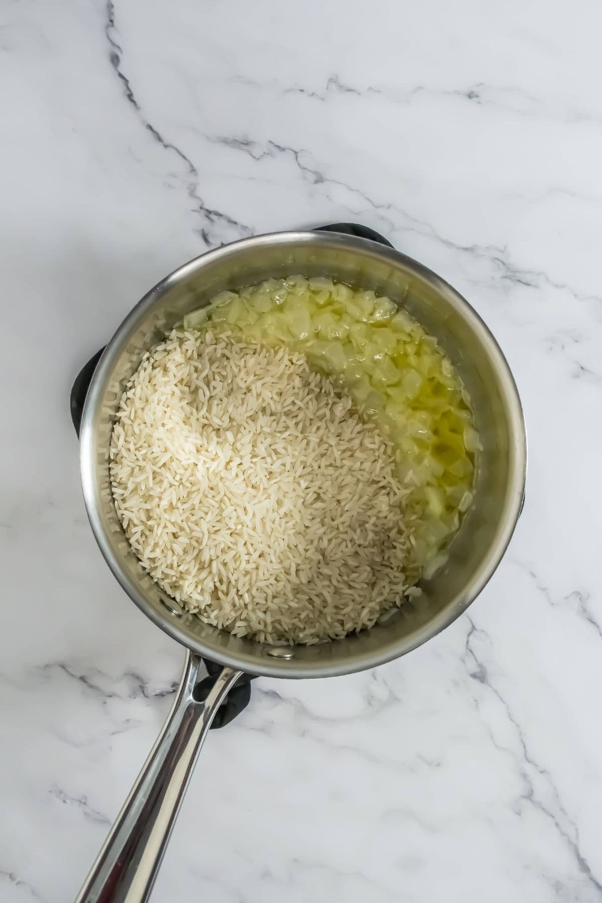 white rice added to the saucepan with the sautéed onions and butter.