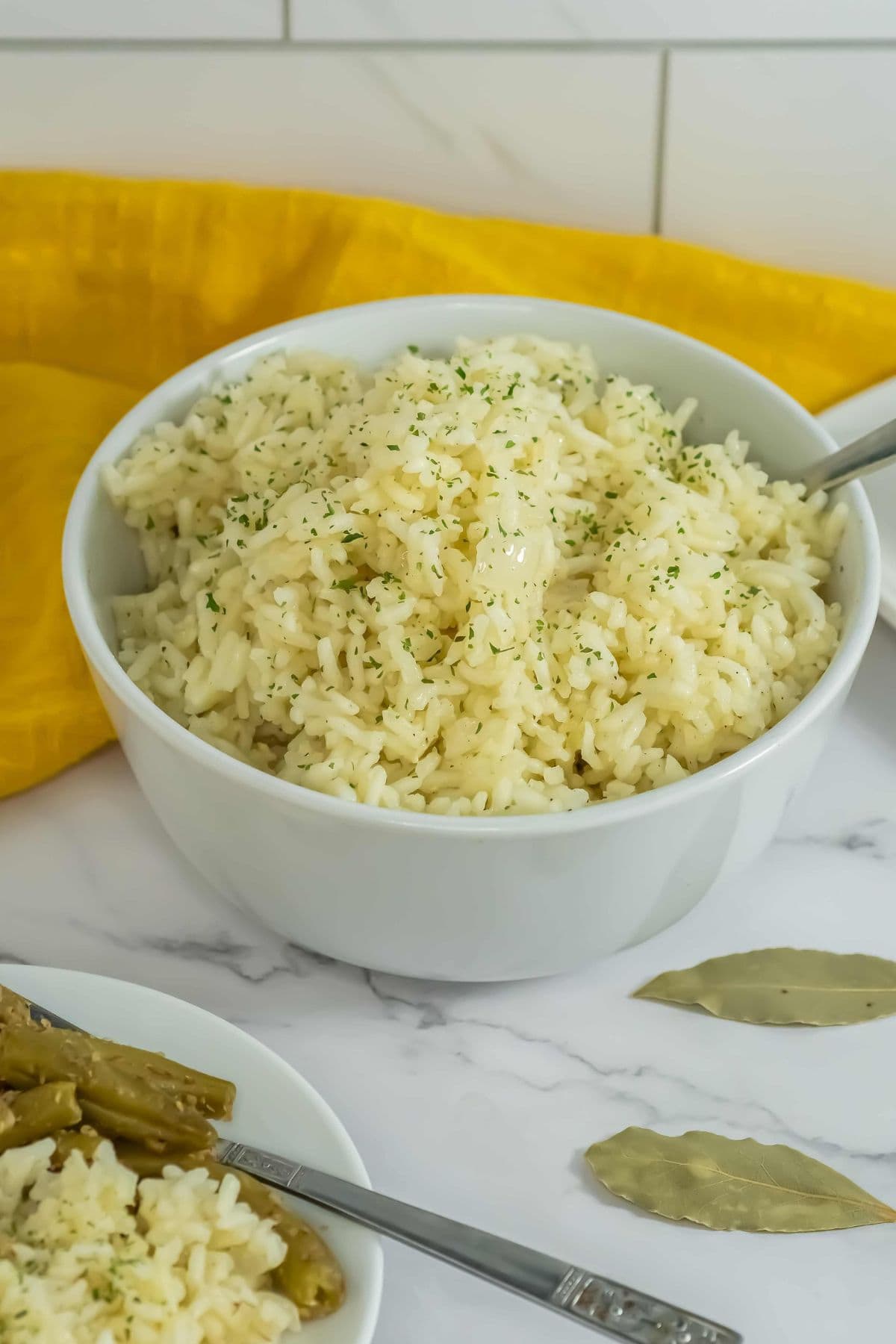 Close-up of butter rice served in a bowl with a yellow cloth background.