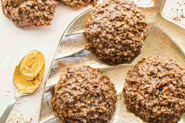 Closeup of chocolate no bake cookies on a gold tray with peanut butter nearby