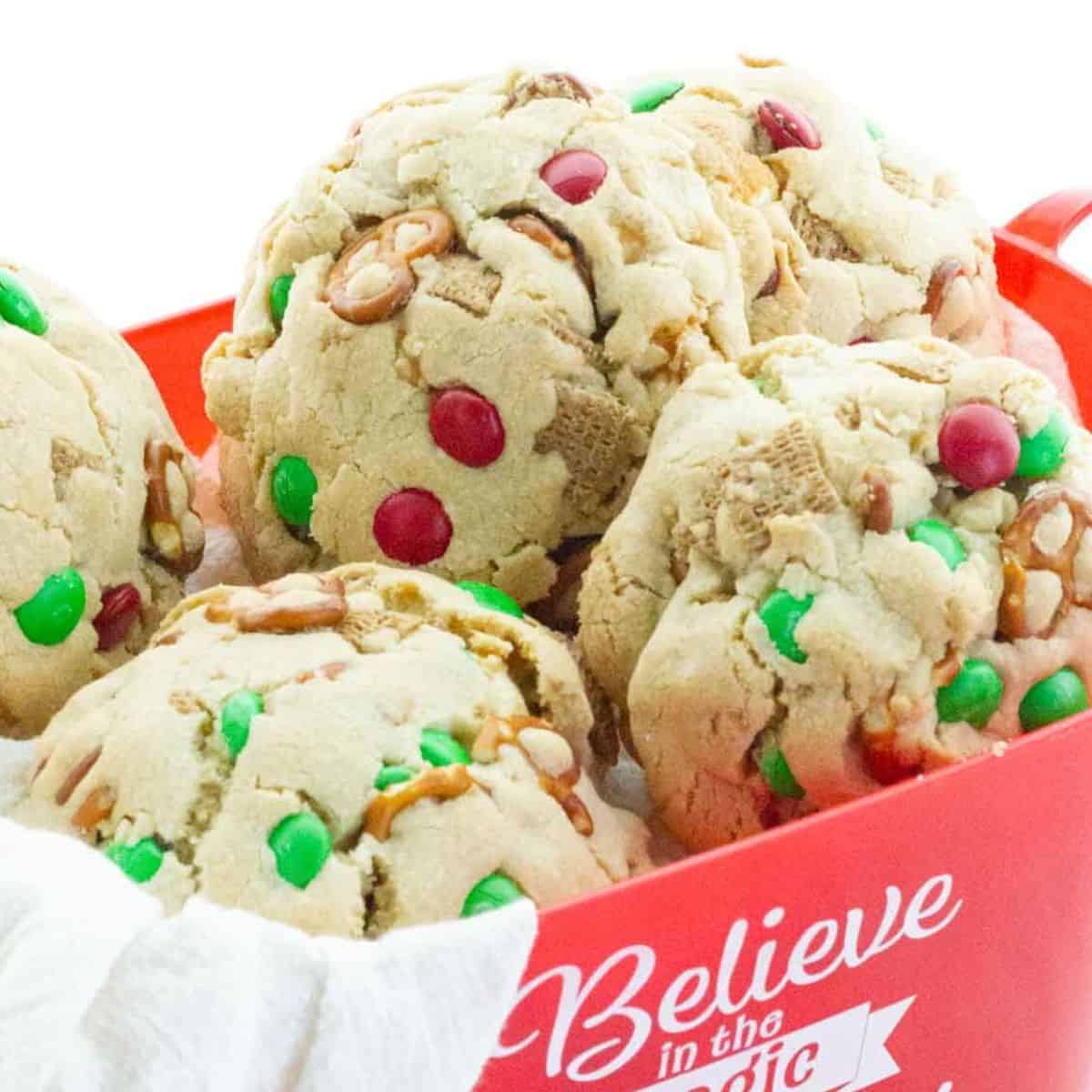 Large, chunky Christmas Kitchen Sink Cookies loaded with pretzels, Chex cereal, caramel popcorn, and red and green M&Ms.