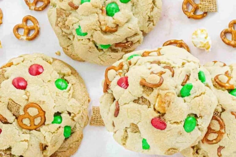 Freshly baked Christmas kitchen sink cookies with visible pretzels, M&Ms, and cereal scattered around them