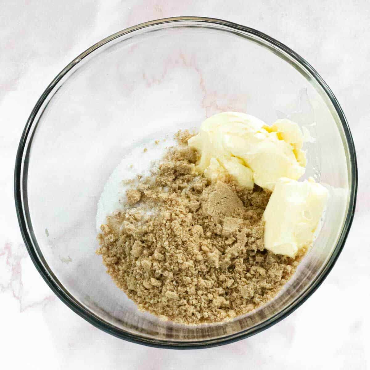A bowl with brown sugar, granulated sugar, and softened butter, ready for mixing.