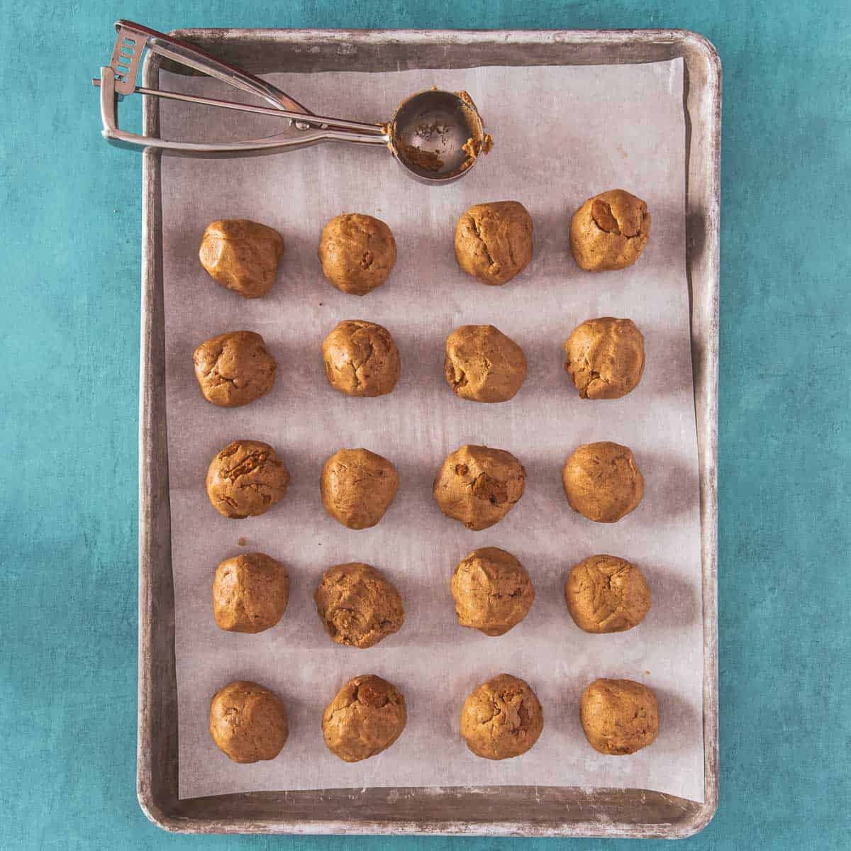 Perfectly shaped dough balls on a baking tray.
