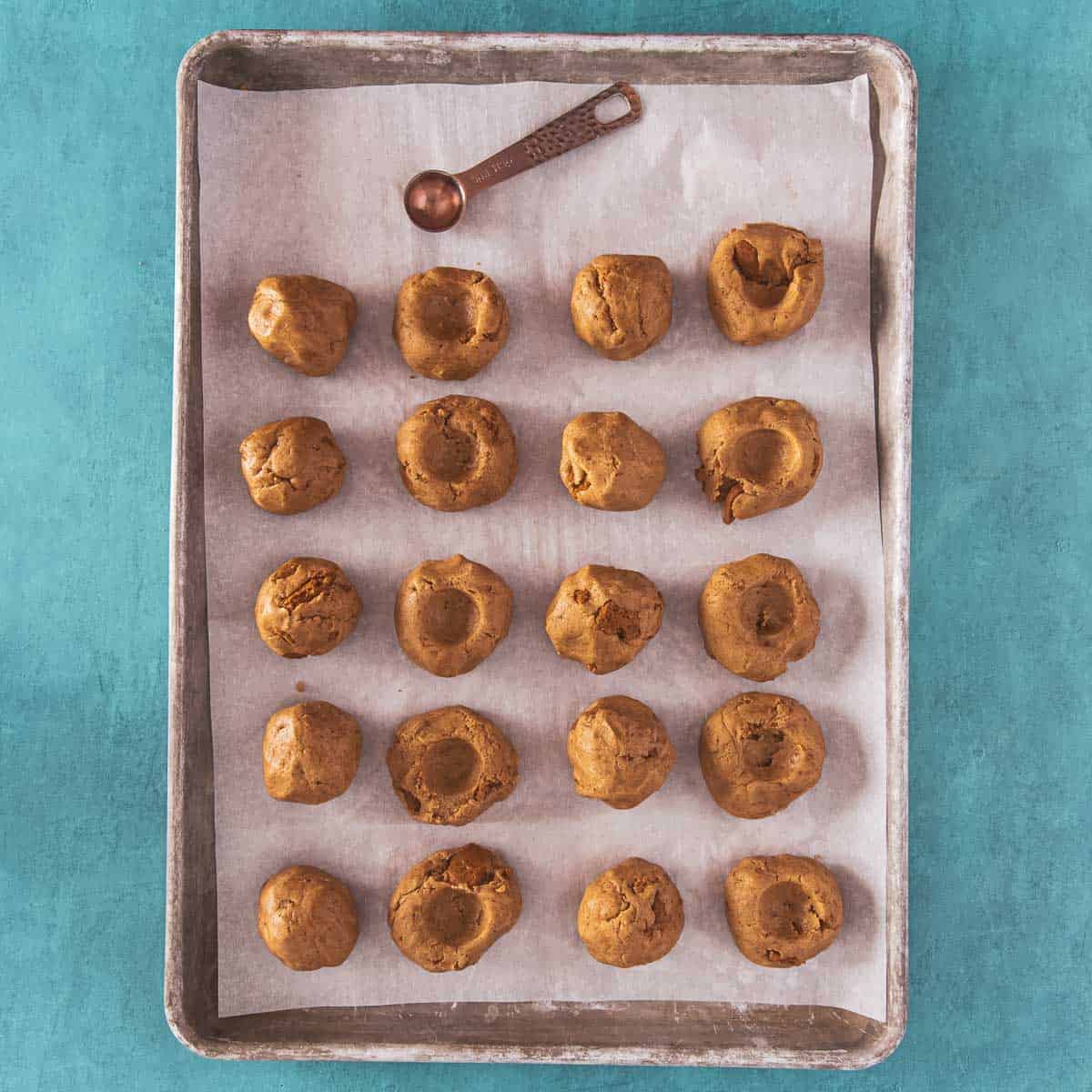 Thumbprint-style indentations made in cookie dough.