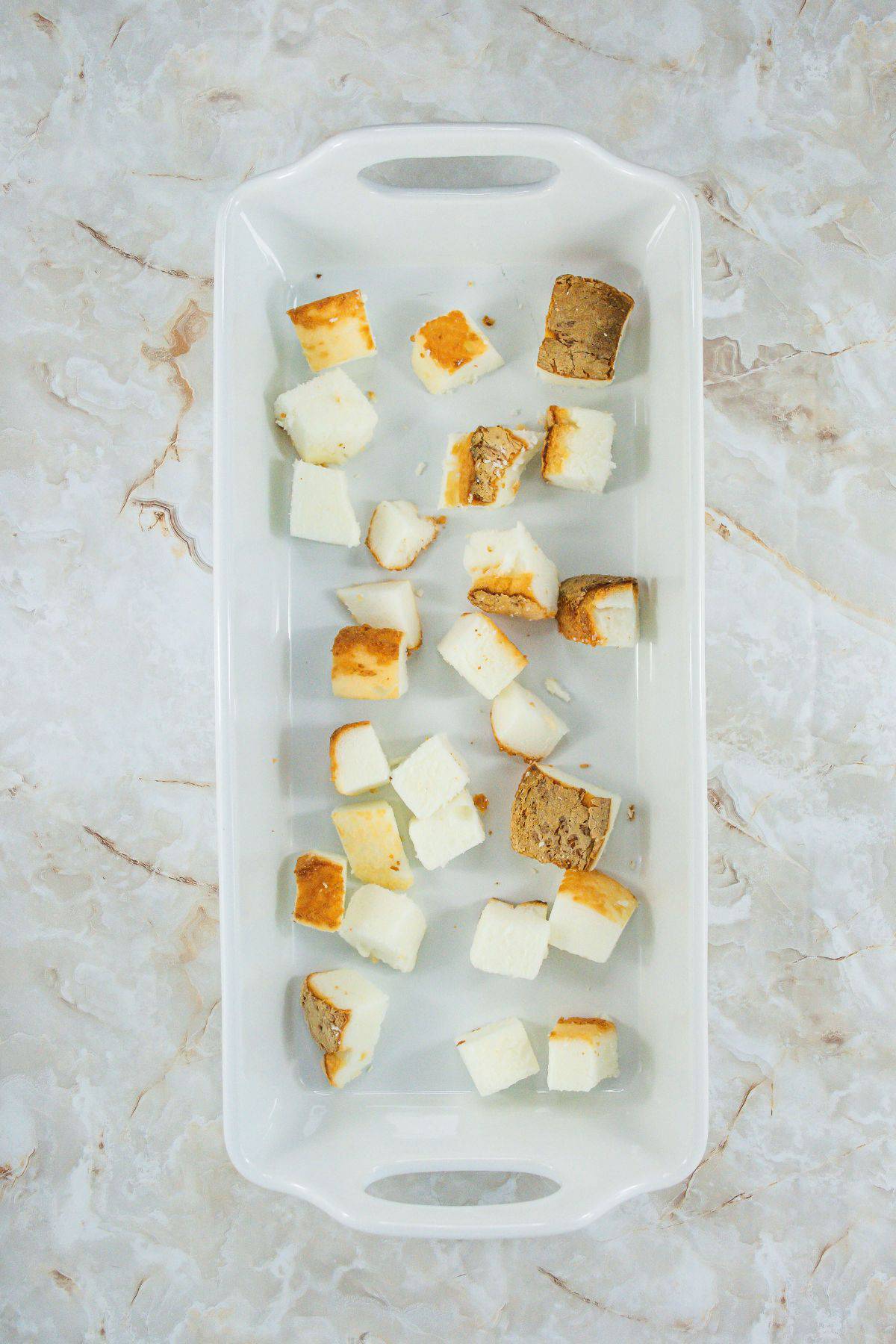 Cubes of angel food cake scattered in a baking dish.