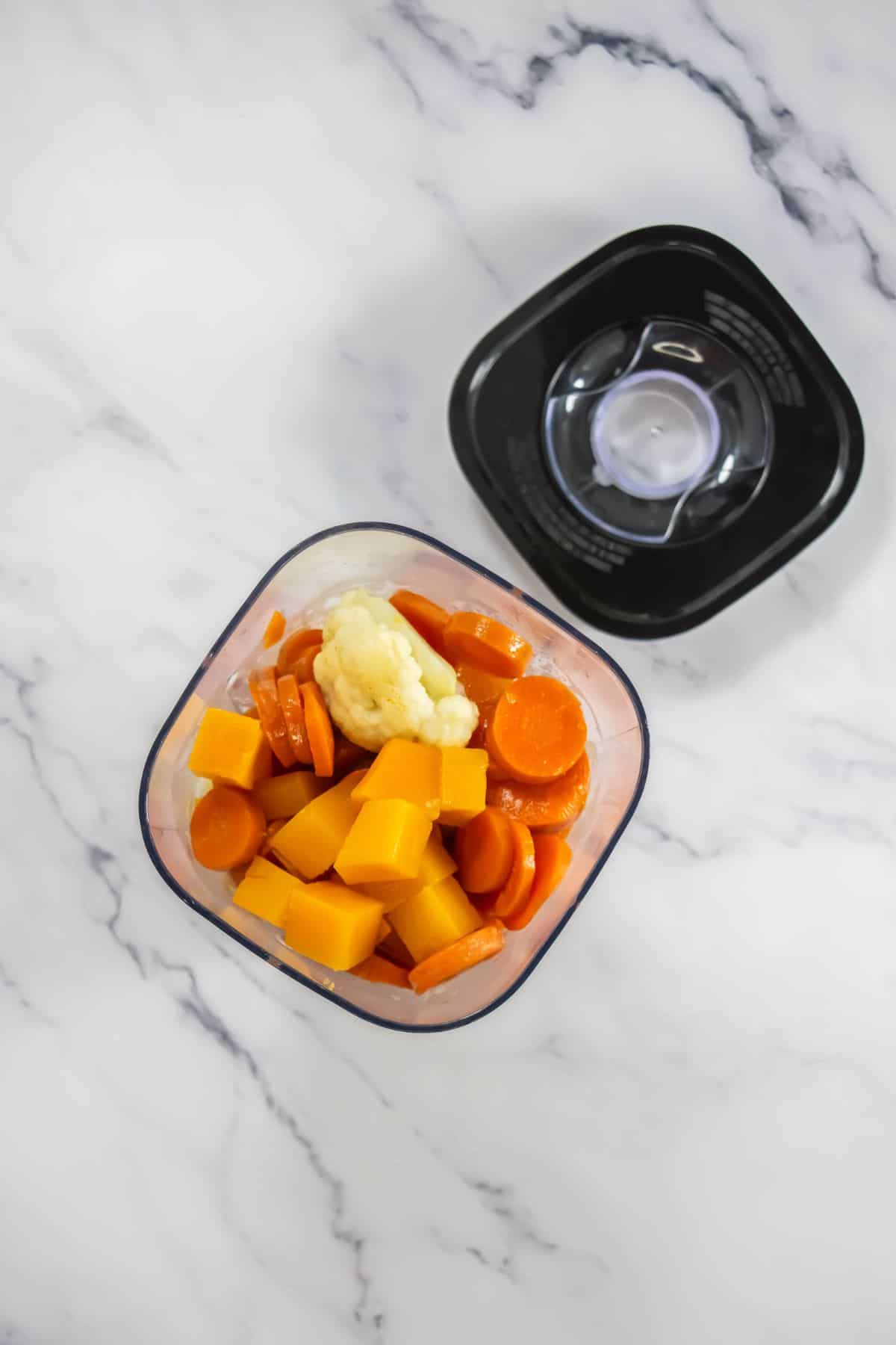 Diced carrots, squash, and cauliflower in a blending container, ready to be pureed.