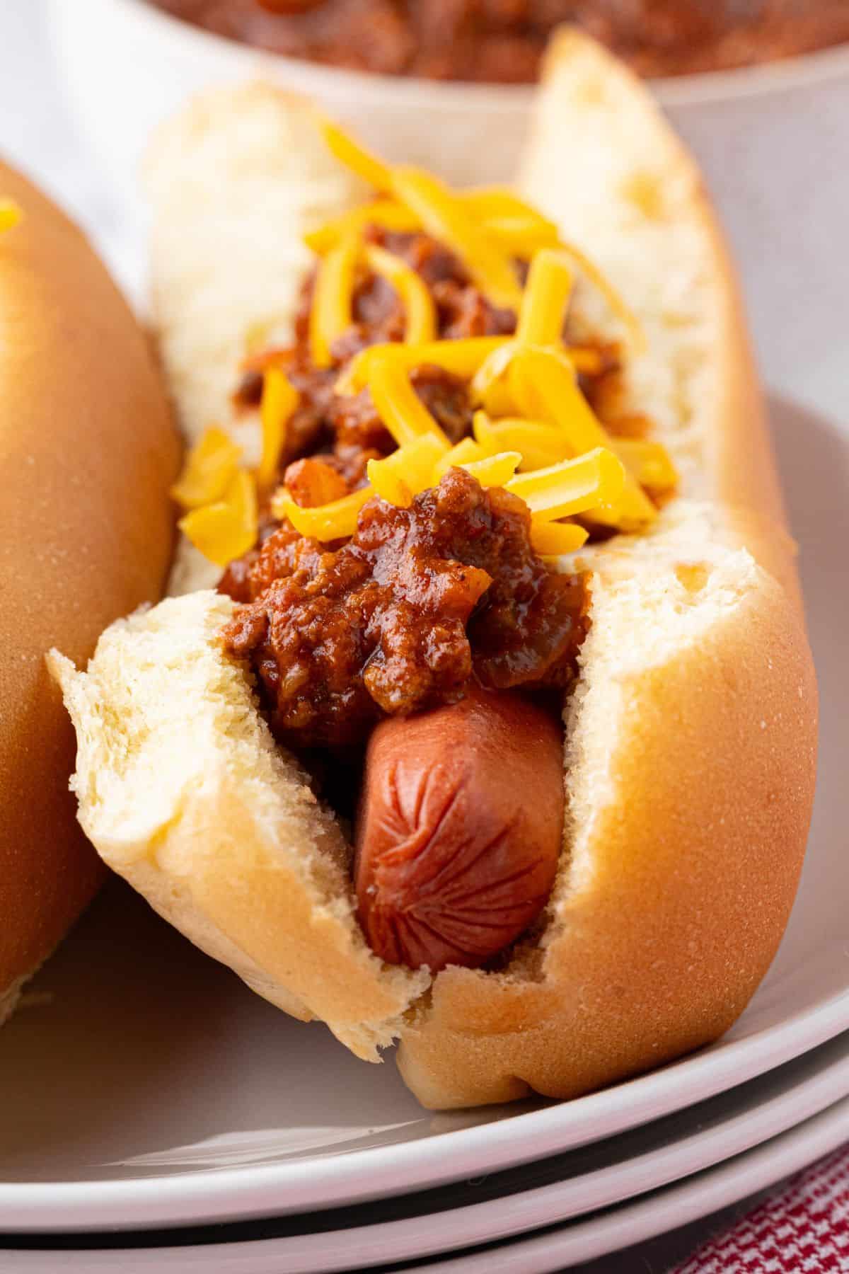 A hot dog with chili and cheese in a soft bun, ready to be enjoyed.