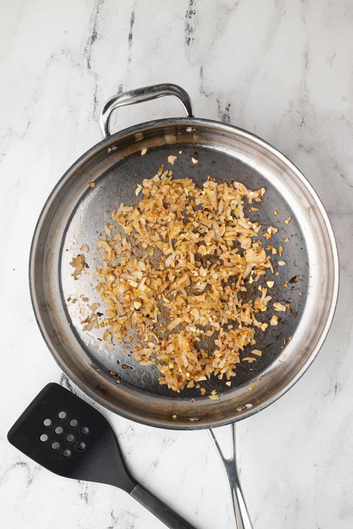 A pan with sautéed onions, showing a golden brown color.