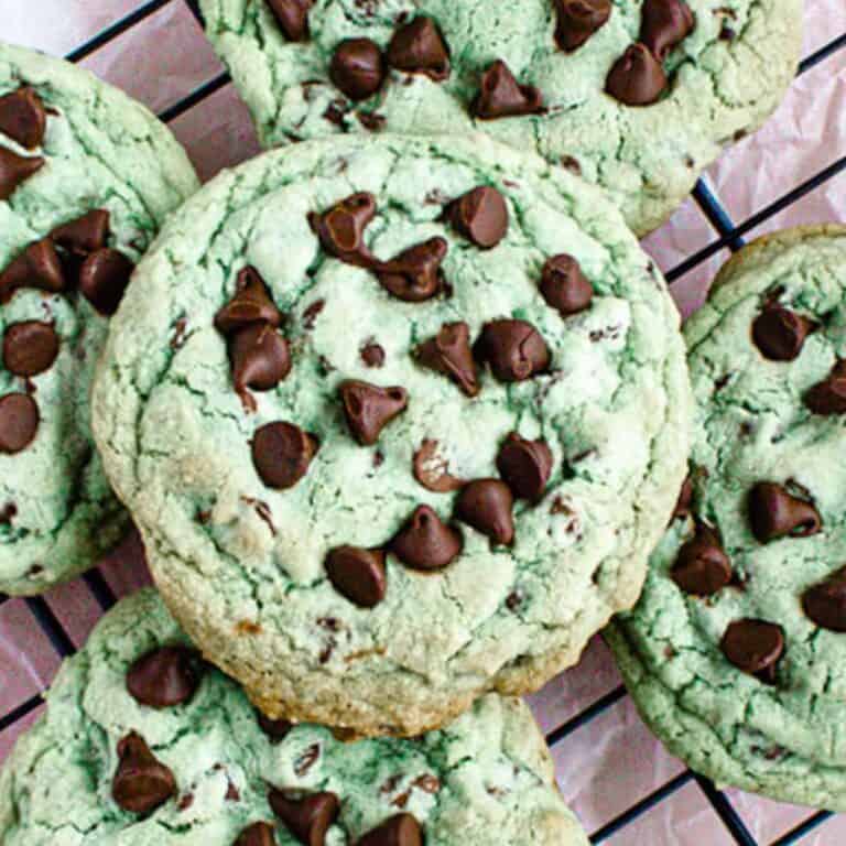 Freshly baked mint chocolate chip cookies with a green hue and chocolate chips scattered on top.