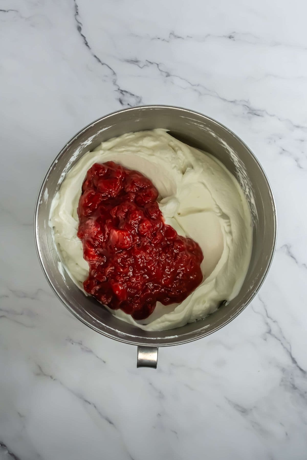 The whipped cream mixture with strawberry compote added on top