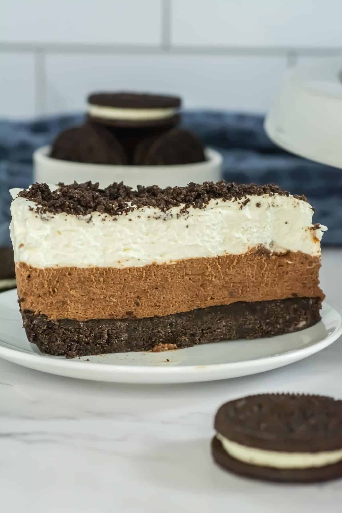 A single slice of Oreo mousse cake displayed, focusing on the creamy, chocolatey layers.