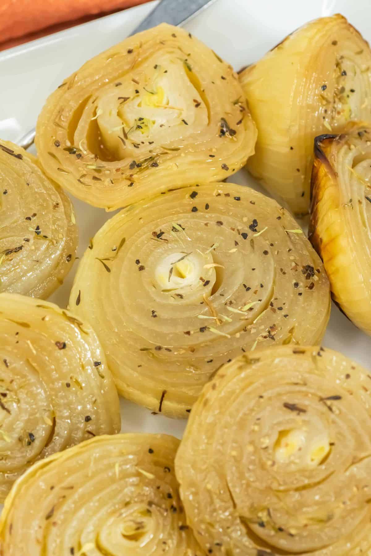Extreme close-up of a roasted onion half, showcasing its layers and seasoning.