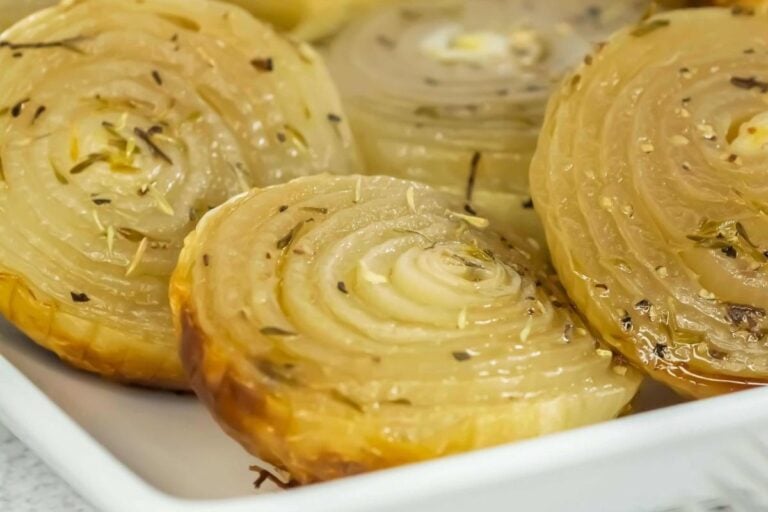 Close-up of roasted onion halves, seasoned and plated for serving