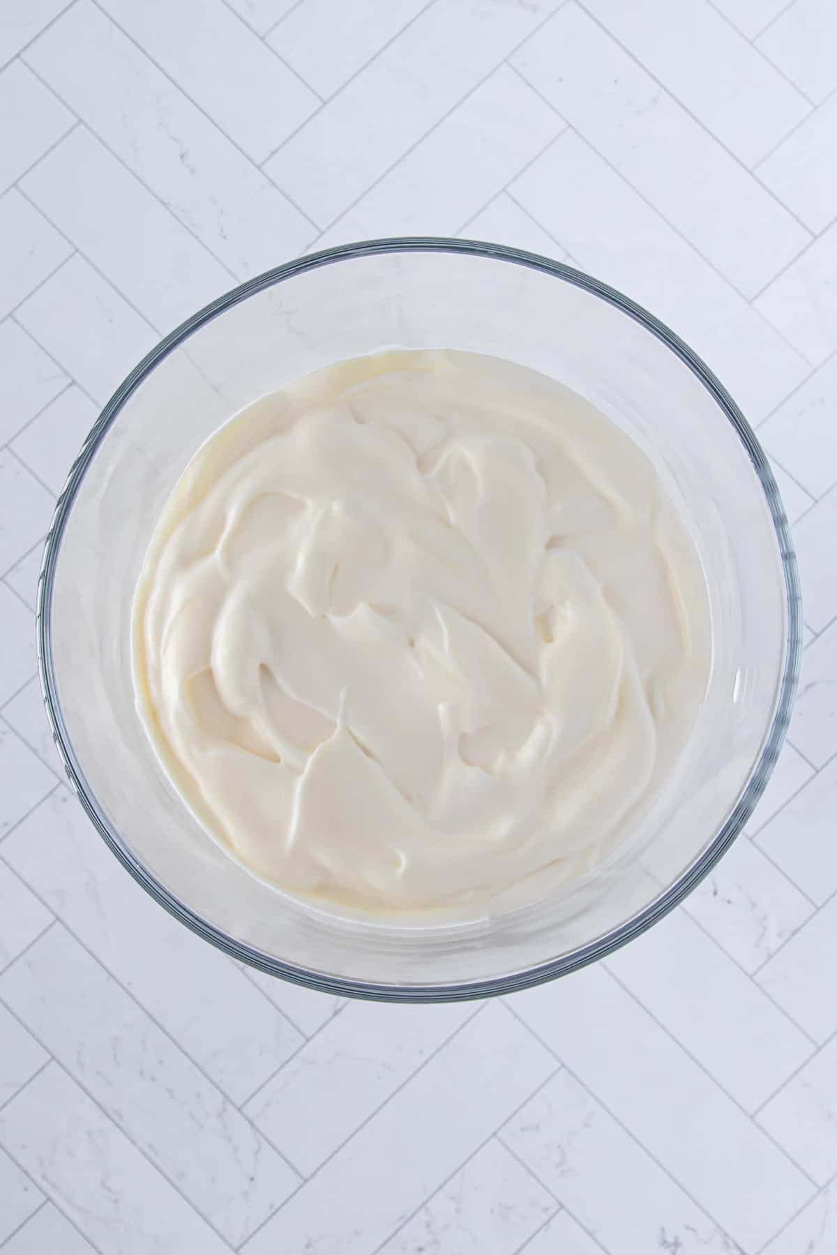 half of the prepared white chocolate pudding spread over the first layer of angel food cake cubes in a large glass trifle bowl