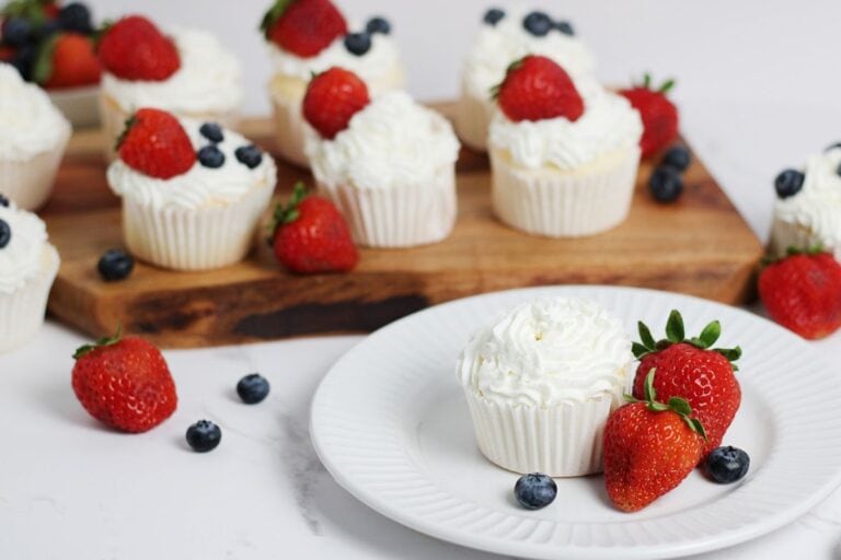 angel food cake cupcakes with whipped cream topping all displayed with fruit
