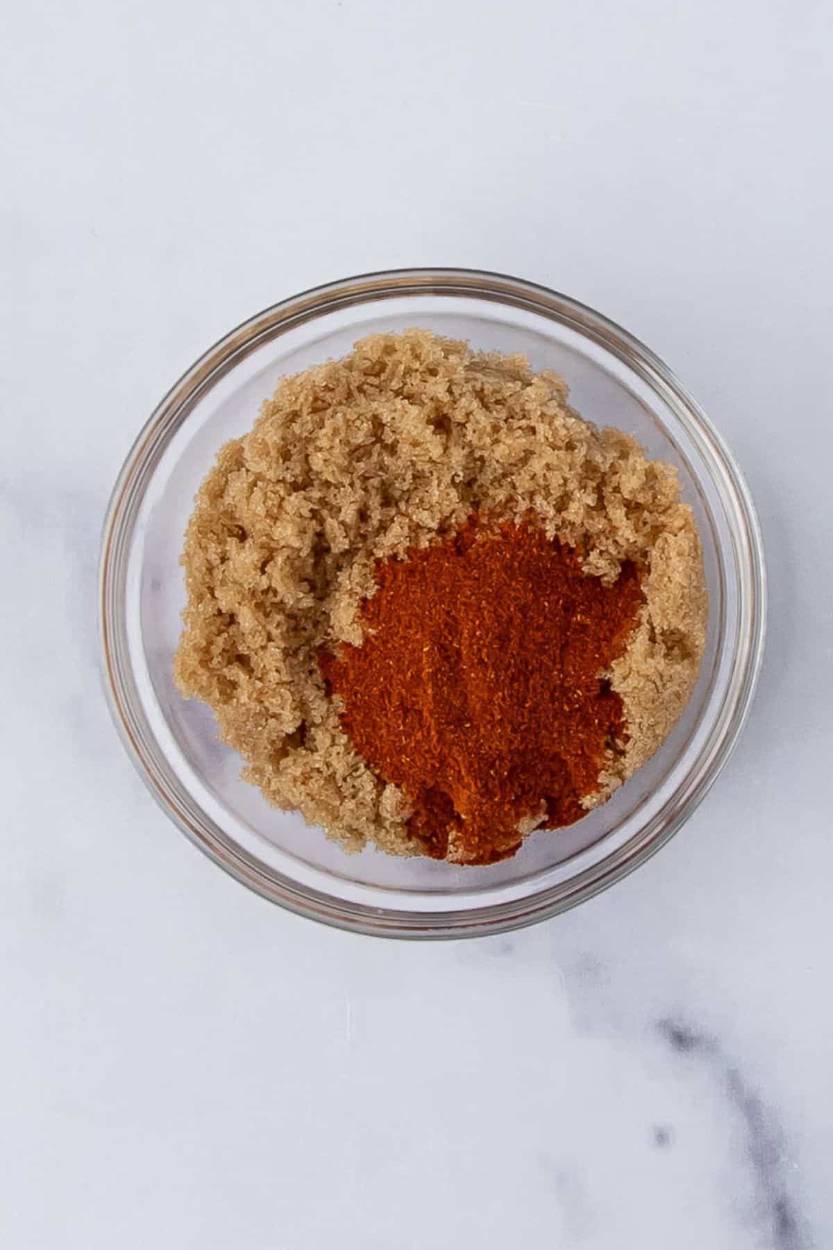 A bowl containing a mix of brown sugar and paprika