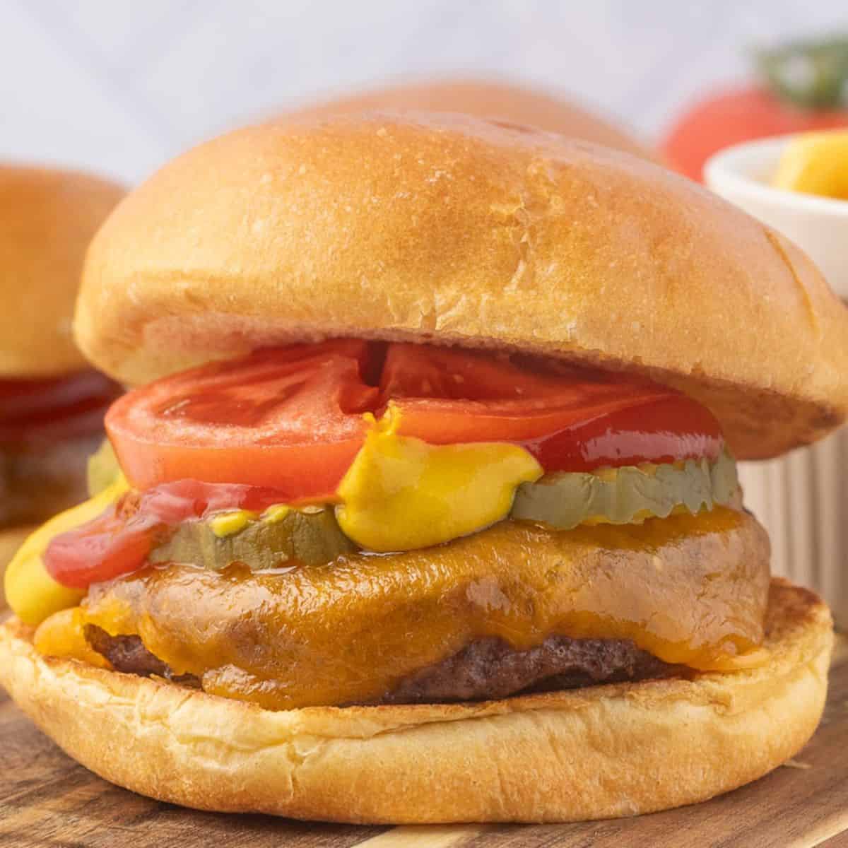 baked hamburger patty with cheese on a bun with toppings