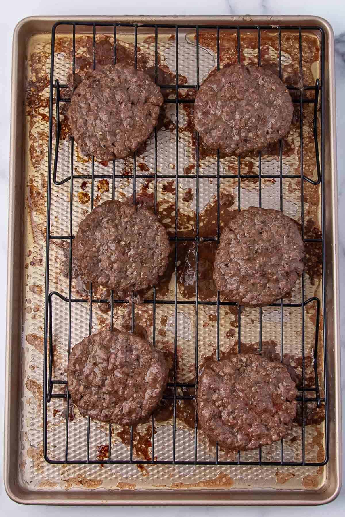 Patties after baking, without cheese, on a baking rack.