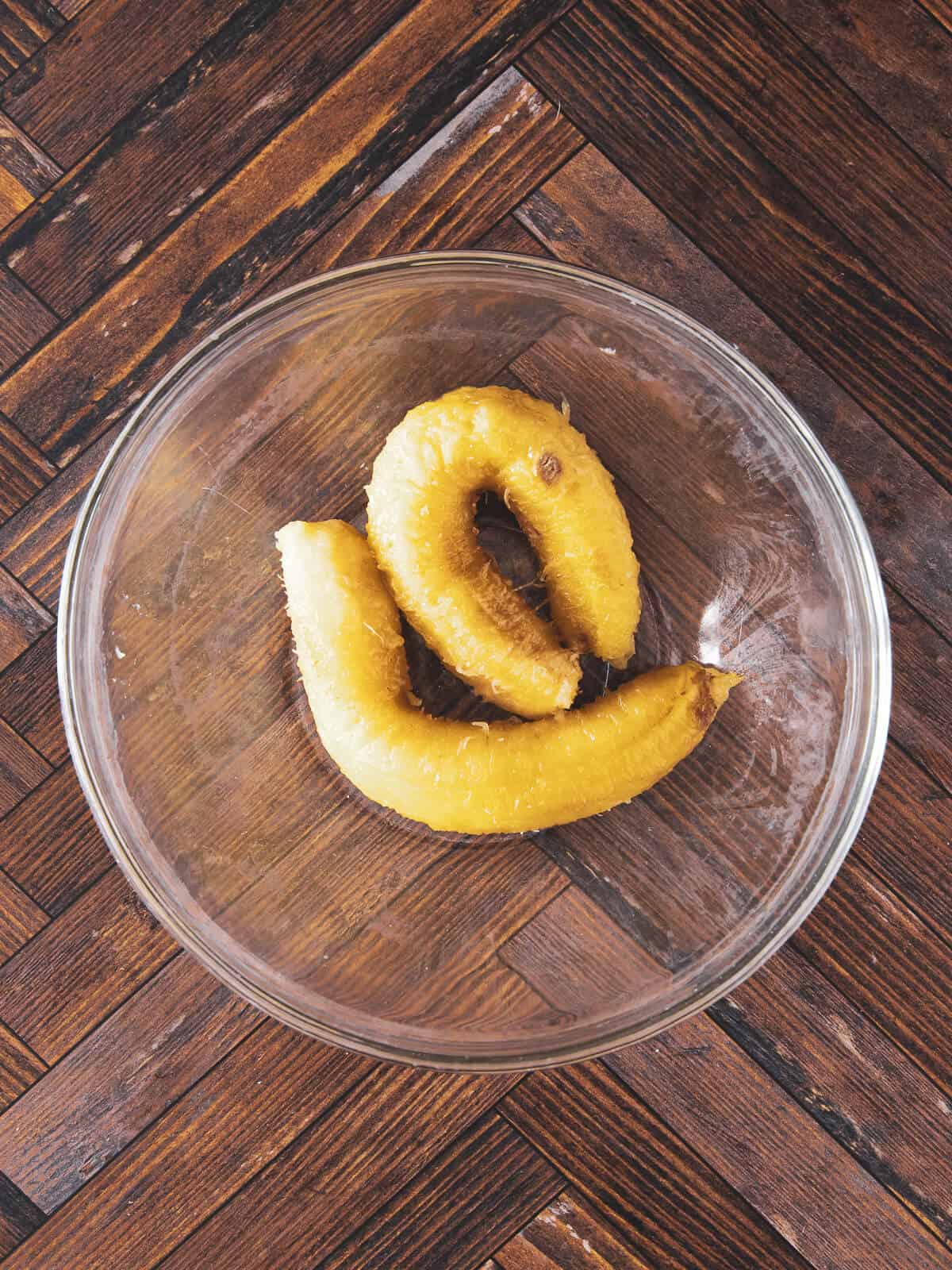 A bowl containing mashed ripe bananas, ready for mixing.