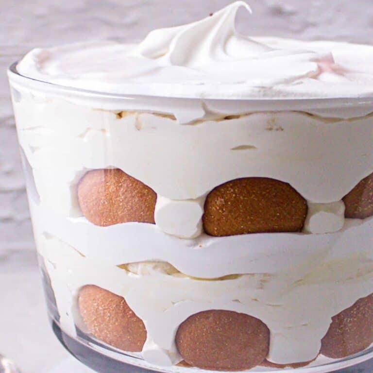 Banana pudding made with cream cheese layered in a dish showing the fresh bananas, vanilla wafers and banana pudding.