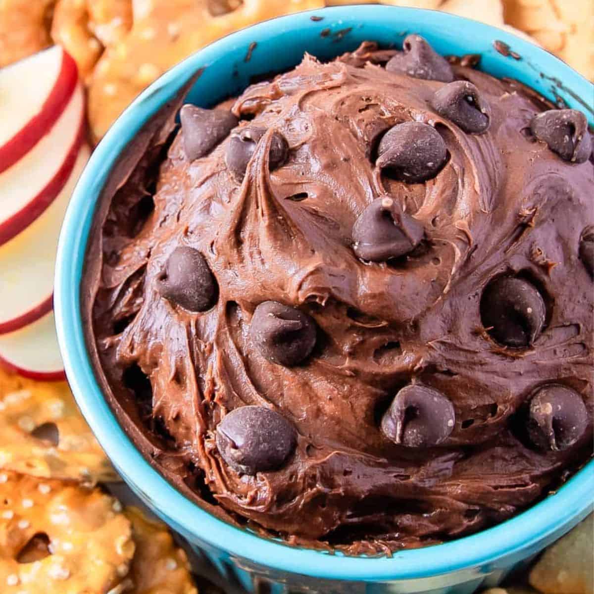 brownie batter dessert dip topped with chocolate chips in a blue bowl