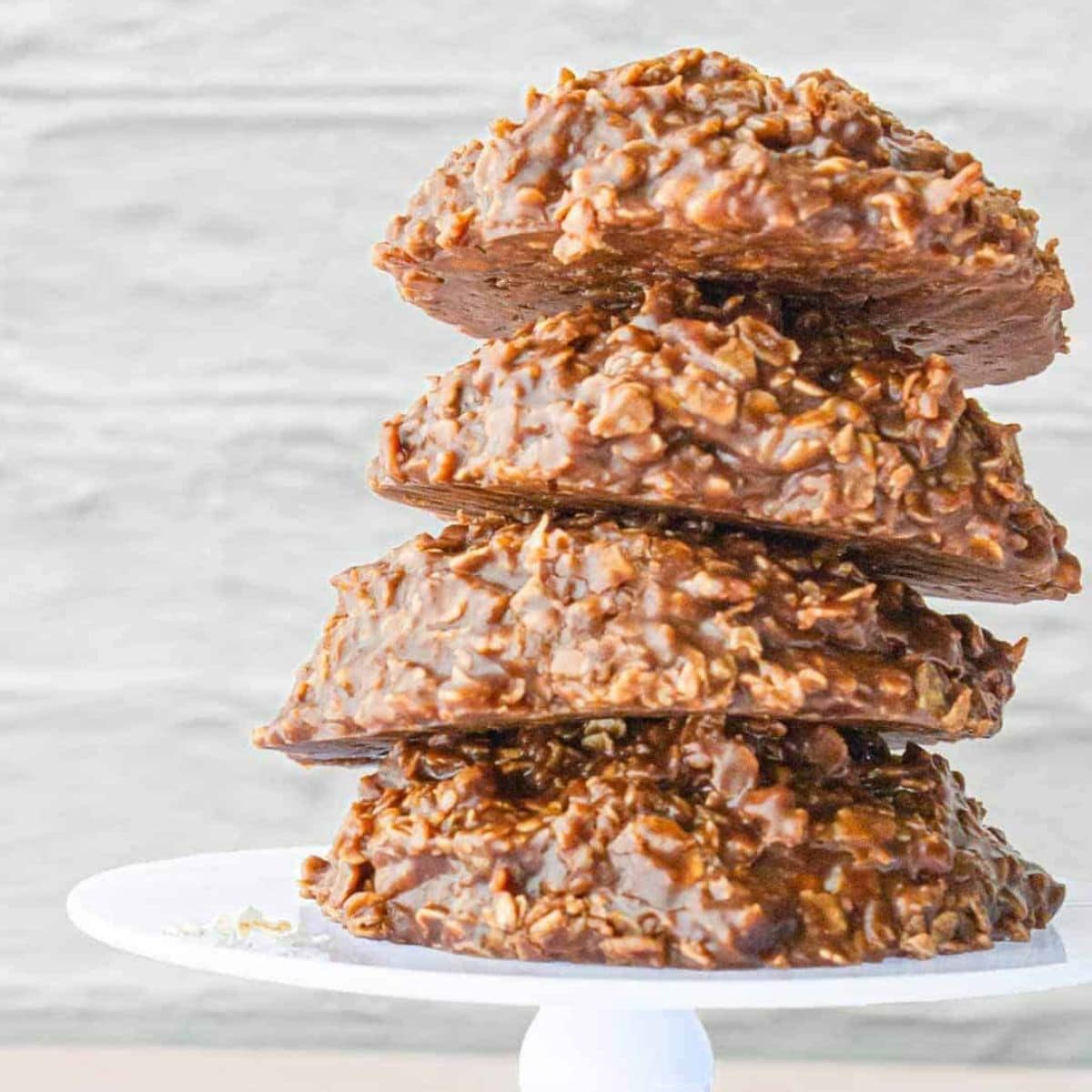 4 chocolate no bake cookies stacked on top of each other on a white tray
