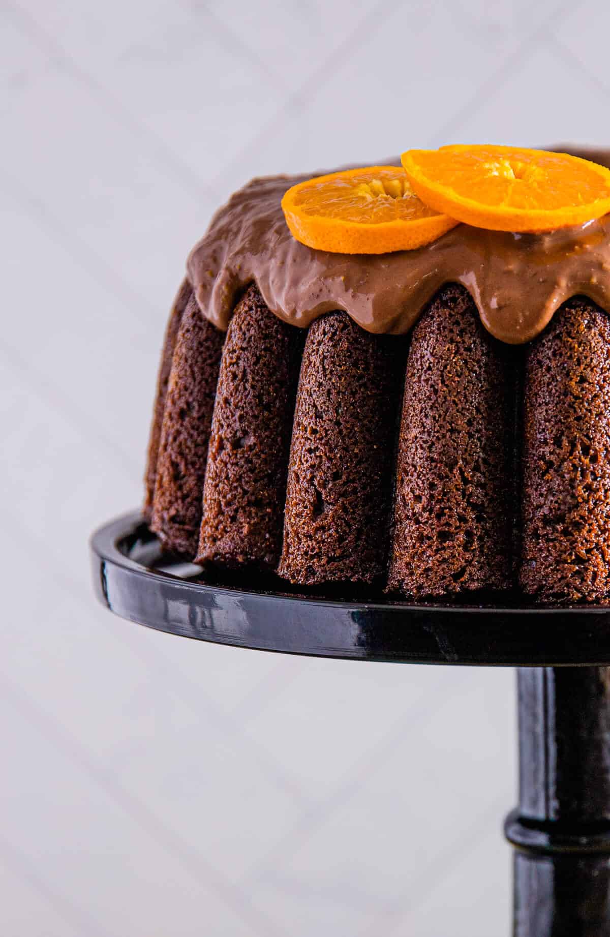 A detailed side angle showcasing the cake's texture, deep brown color, and smooth glaze.