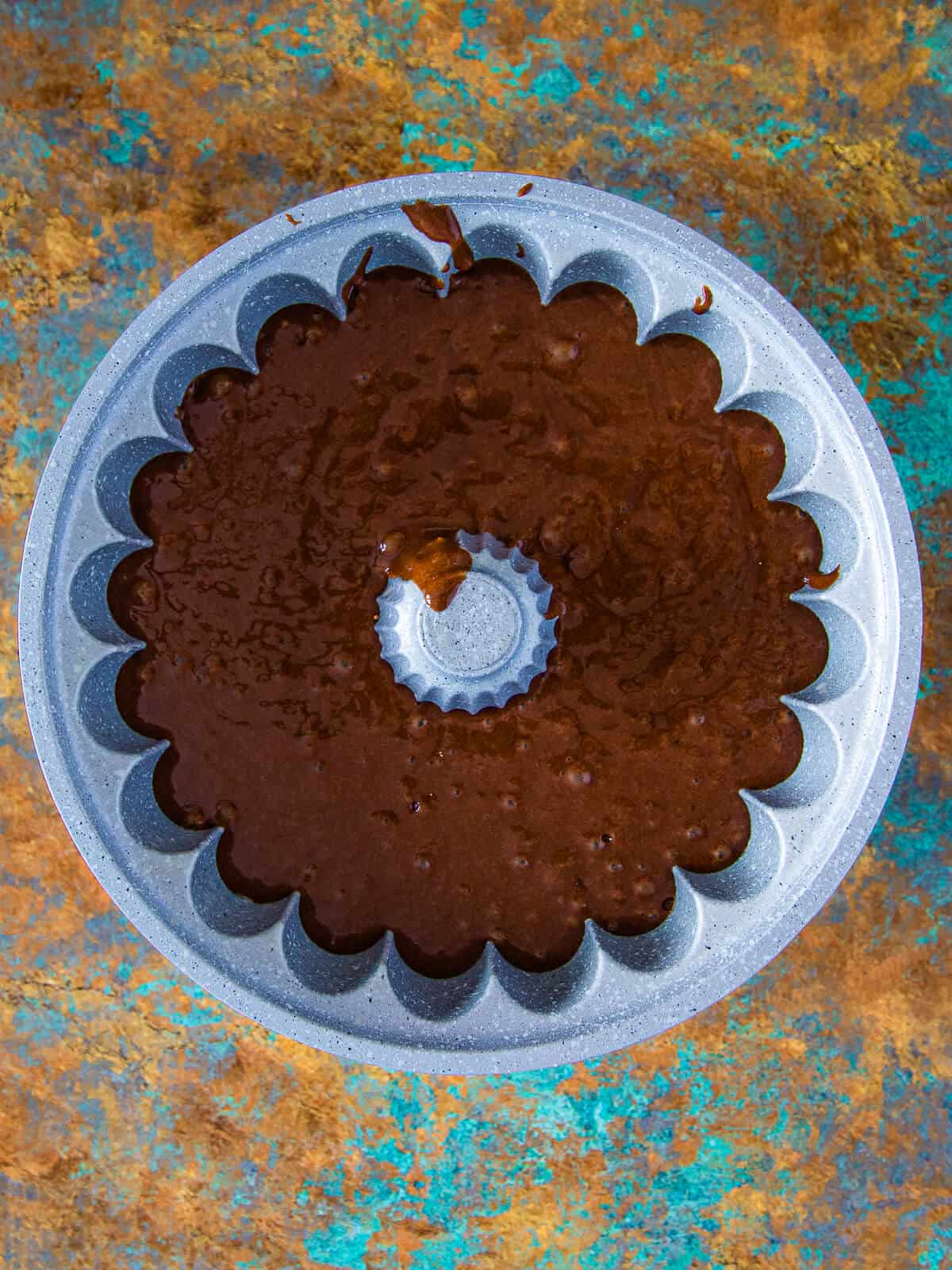 A bundt cake pan filled with the prepared chocolate cake batter, ready for baking.