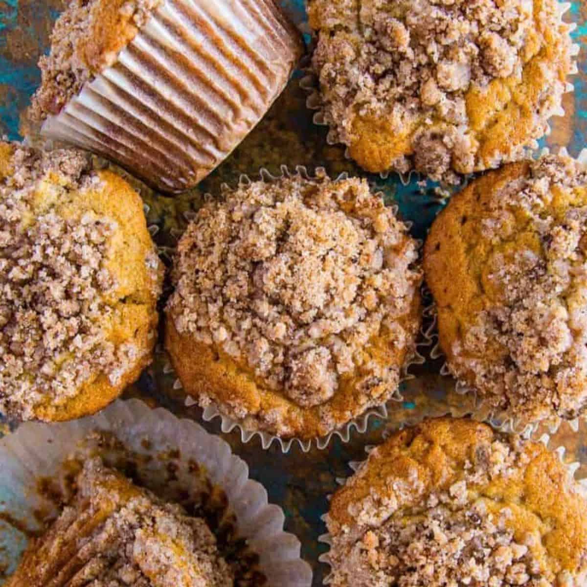 cinnamon muffins with a streusel topping on a table.