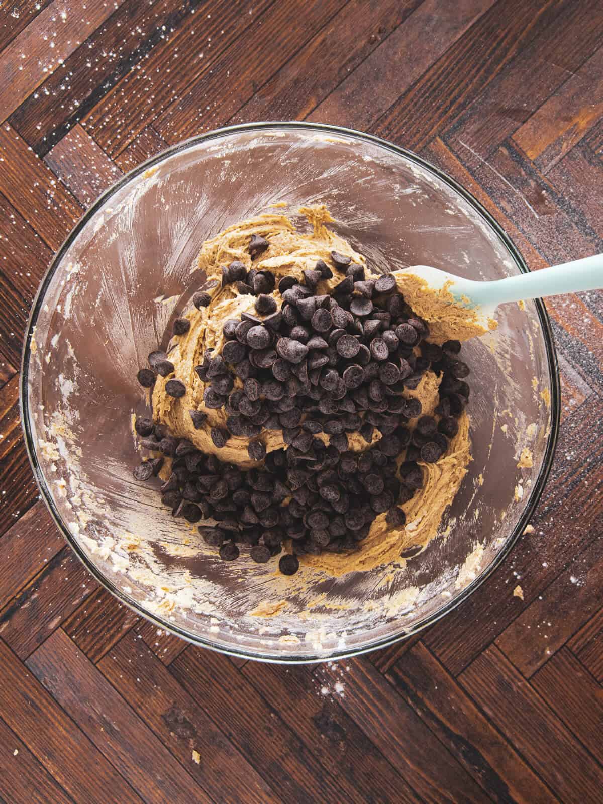 A bowl of cookie dough with espresso morsels being folded in.