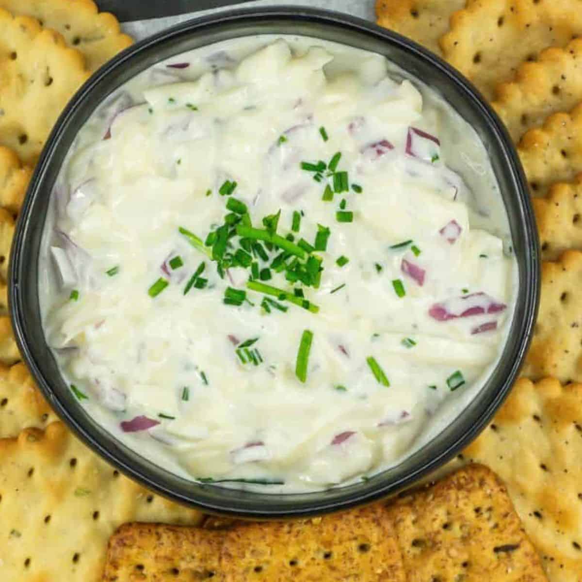 Jarlsberg cheese dip made with shredded jarlsberg, mayo, onions, pickle juice served with a tray of crackers.