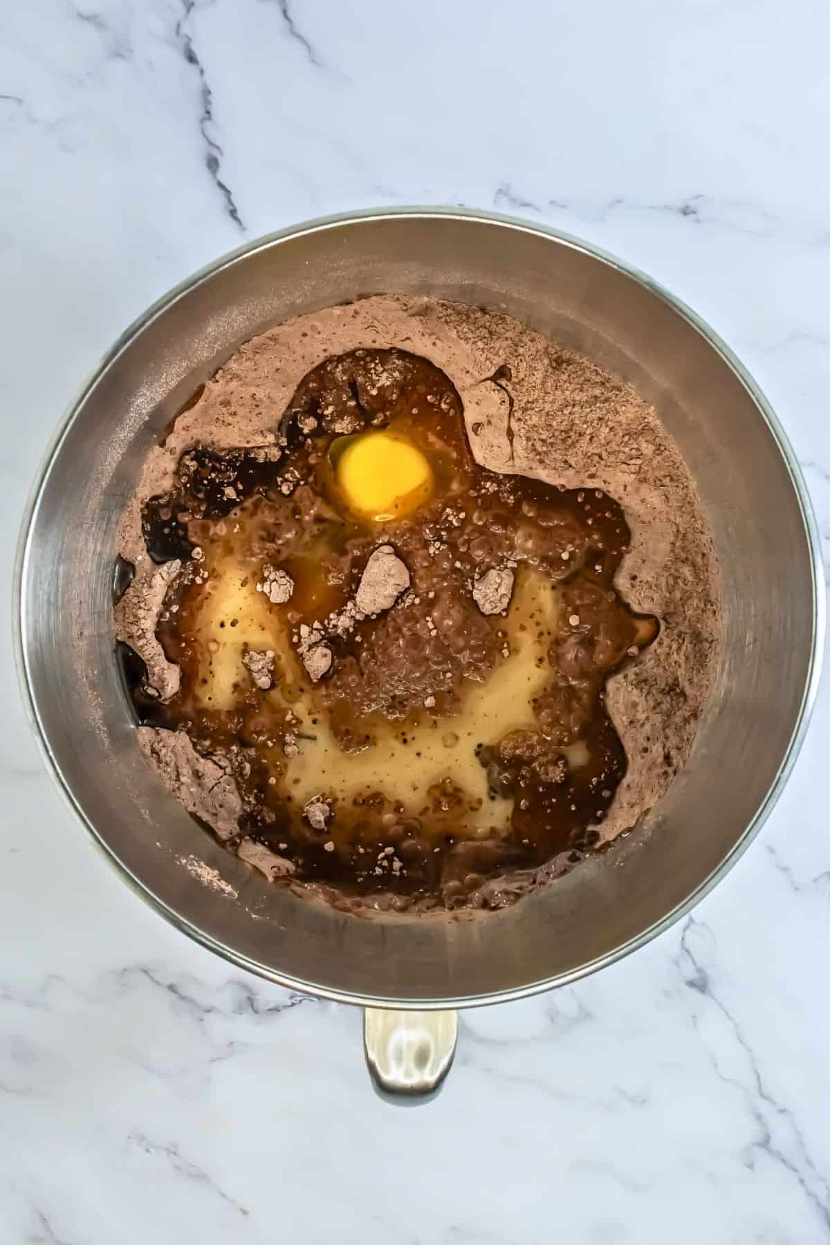 stand mixer bowl after dry ingredients for chocolate cupcake mix has been made with the wet ingredients on top