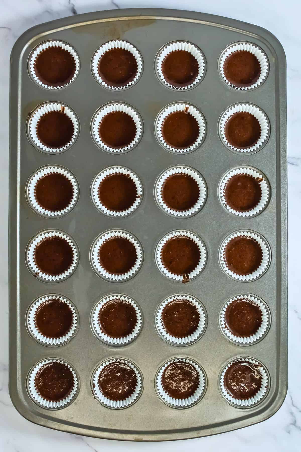 mini cupcake tin filled with 24 chocolate mini cupcakes before baking