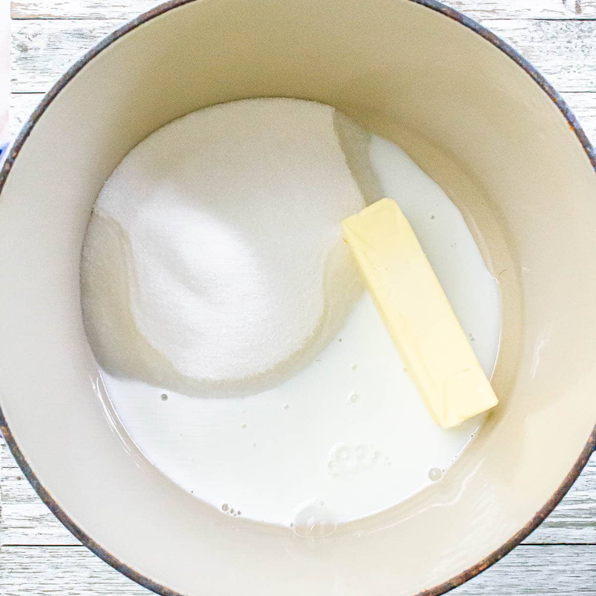 Sugar, butter, and milk in a pot, ready to be melted together.