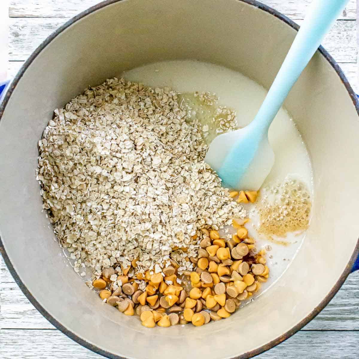 Oats, butterscotch chips, and vanilla are added to the melted sugar mixture, ready to be combined into the cookie dough.