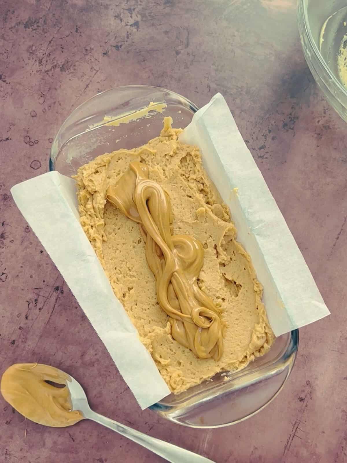 A thick swirl of peanut butter added to the top of the batter in the loaf pan.