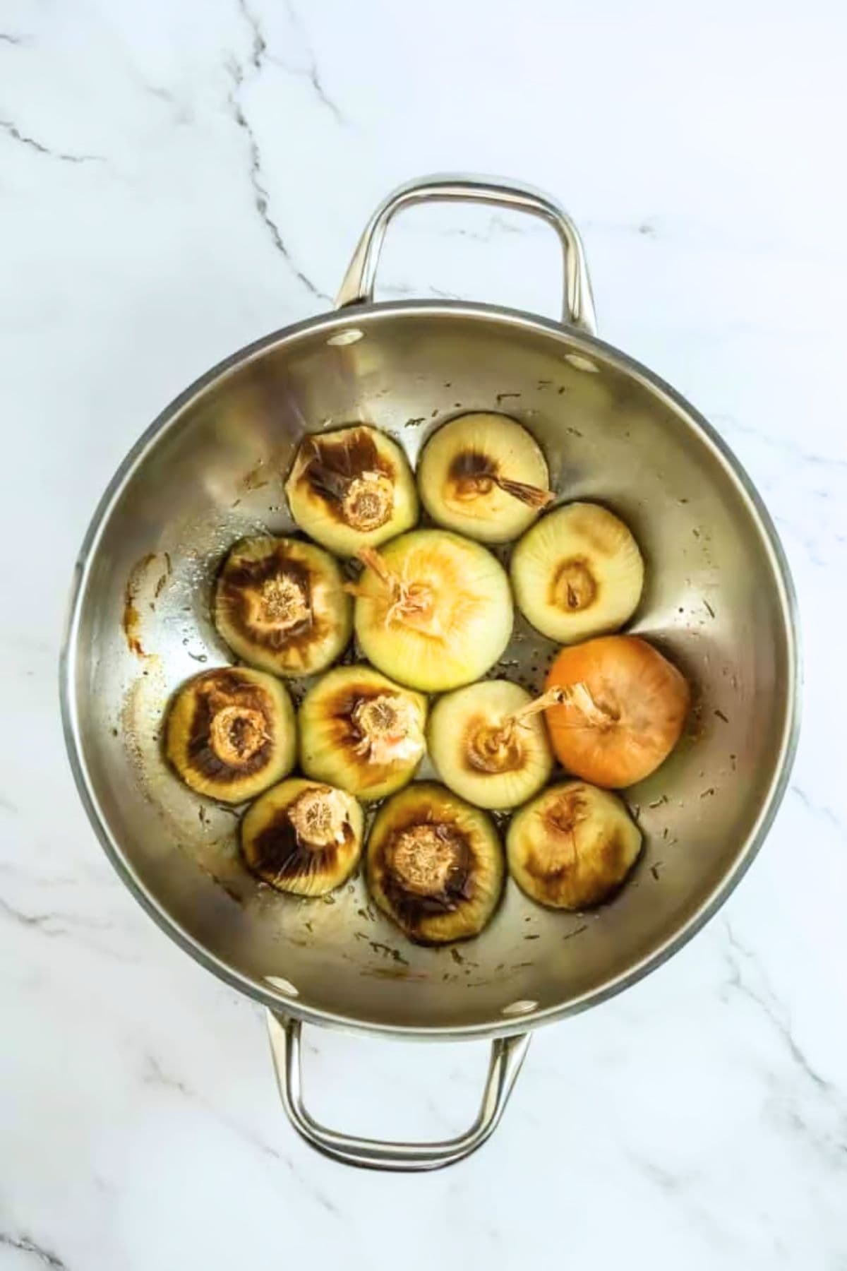 Roasted onions in an oven safe pan after coming out of the oven showing caramelization