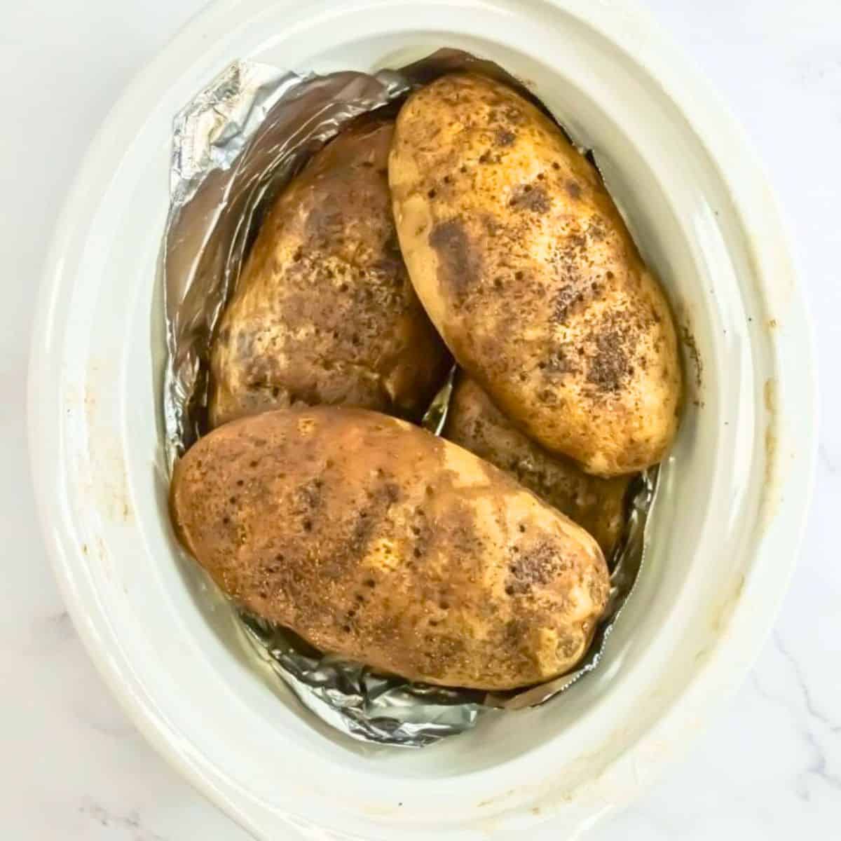Slow cooker baked potatoes after cooking inside a crockpot