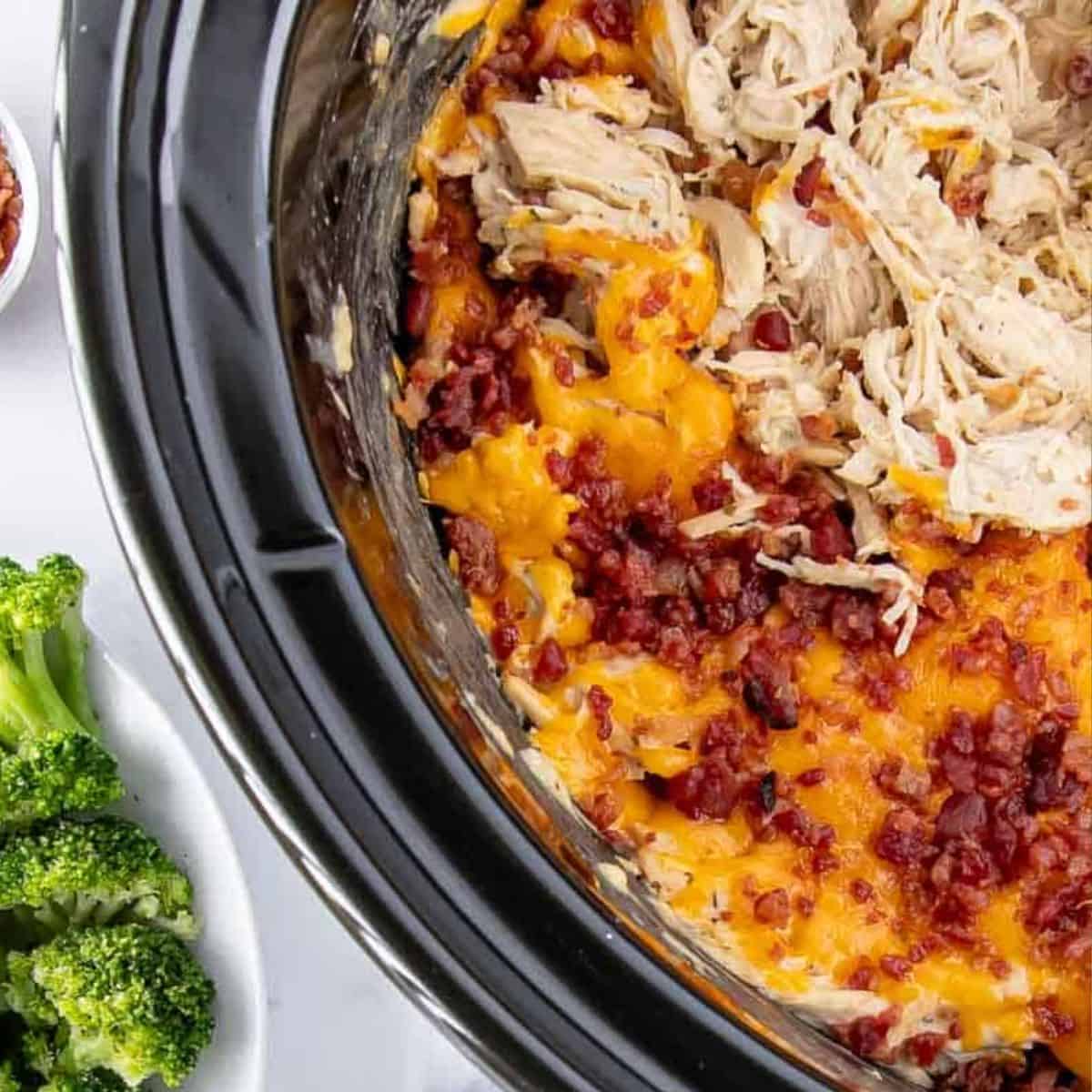 Crack chicken in crock pot with melted cheddar cheese and bacon on top