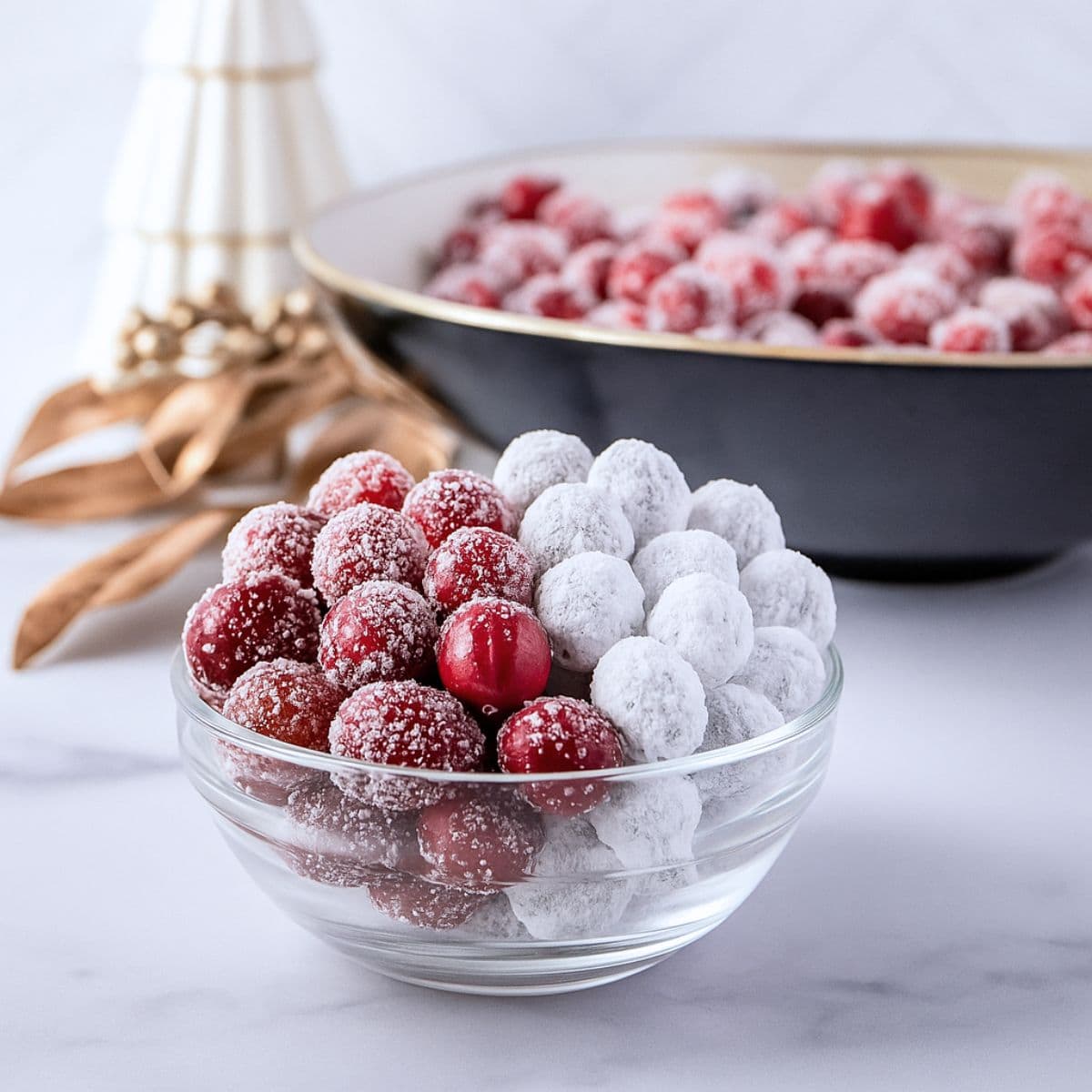 a bowl with half candied cranberries and half sugared cranberries on a marble countertop