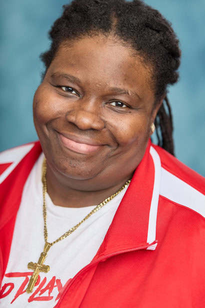Smiling woman in red and white sports jacket, portrait for sports or community event.