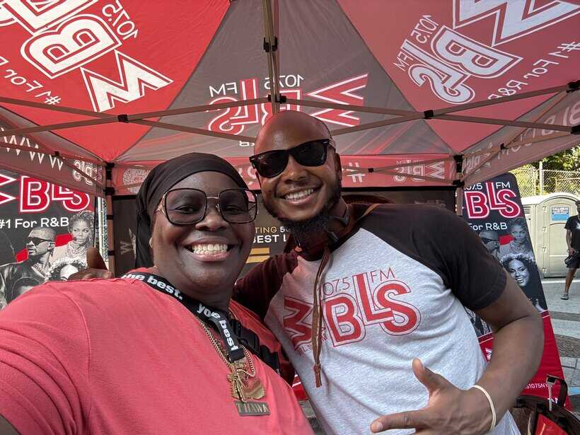 UOhnIt.com promotional event with smiling radio hosts at BLS radio station outdoor booth.