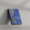 Thoughtful blue book titled "Wisdom for the Week" with ornate gold design featuring a peacock on the cover.
