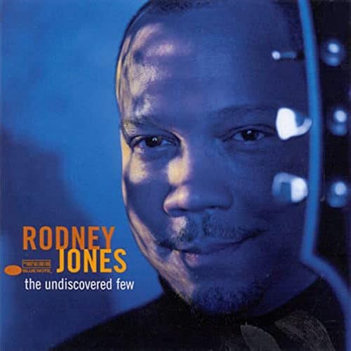 Rodney Jones jazz album cover with artist smiling and musical notes, highlighting smooth jazz and soulful melodies.