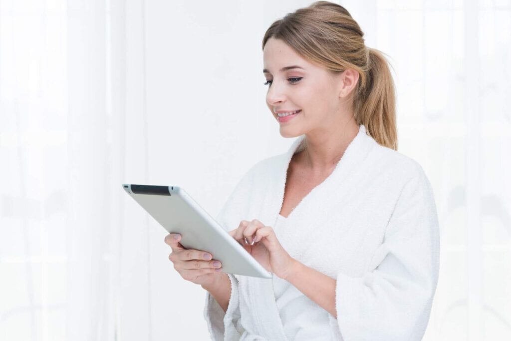 Woman using tablet to find best cosmetic surgeon in Albania for medical tourism.