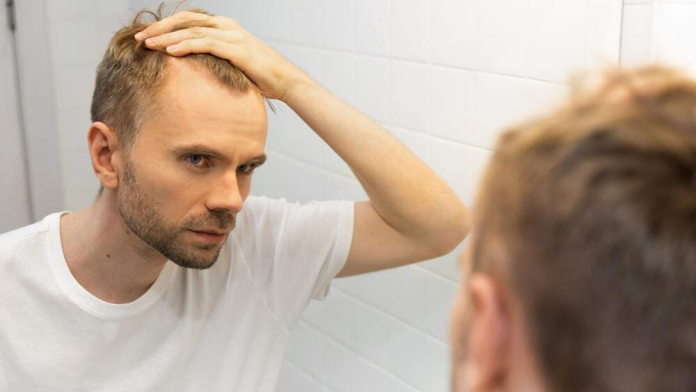 Man considering hair growth treatments