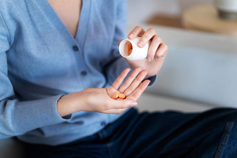 Image illustrating a woman taking medicine after a breast augmentation