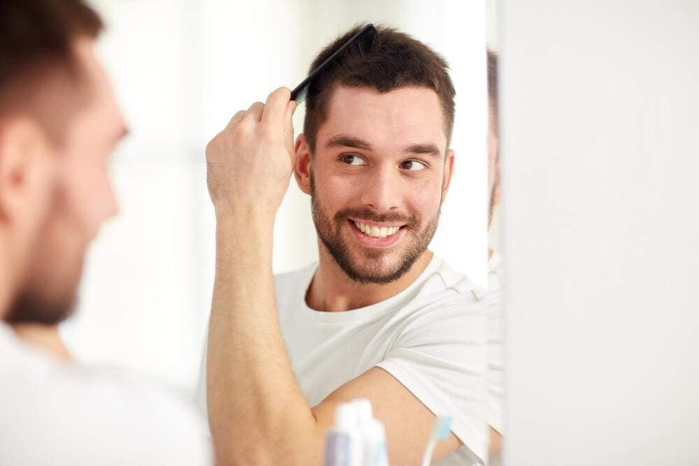 Afbeelding van een man die geniet van zijn nieuwe haargroei na een haartransplantatie.