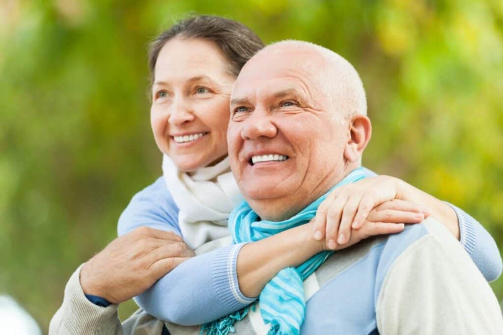 Pareja de ancianos feliz disfrutando del paisaje al aire libre, promoviendo el turismo dental en Albania.